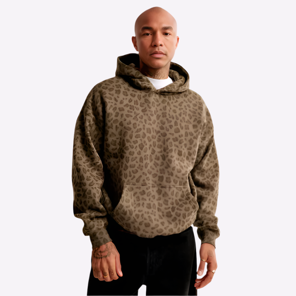 Man wearing a stylish leopard print hoodie, showcasing bold fashion and comfort in a trendy design.